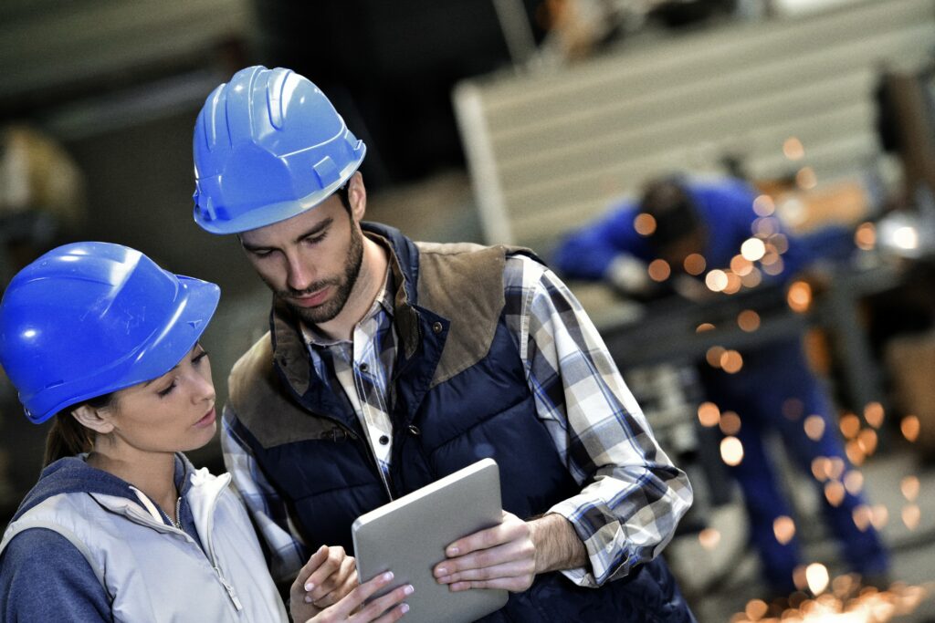 Two construction workers reviewing data on tablet